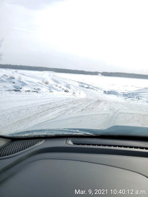 Image of snowy driving conditions, taken from inside a vehicle.